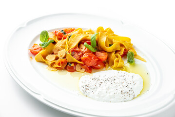 Tagliatelle pasta with cherry tomatoes, garlic, basil, and creamy burrata cheese on a white plate. Gourmet Italian dish with elegant presentation and fresh ingredients.