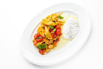 Tagliatelle pasta with cherry tomatoes, garlic, basil, and creamy burrata cheese on a white plate. Gourmet Italian dish with elegant presentation and fresh ingredients.