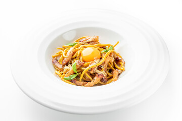 Gourmet spaghetti with pancetta, raw egg yolk, and fresh herbs served on a white plate. Minimalist plating, top view, elegant presentation, Italian cuisine concept.