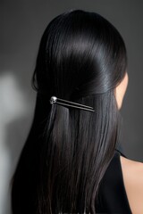 Obraz premium Woman's long straight dark hair styled with an elegant silver hair clip with skull