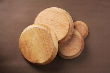 Wooden bowls are stacked on a brown background.