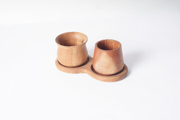 The image shows two wooden cups standing side by side on a white surface.