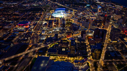 Detroit skyline aerial view at night. Drone night aerial photo of downtown Detroit city lights, Comerica Park, and Little Caesars Arena.