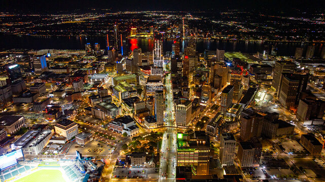 Night aerial view of downtown Detroit skyline and streets. Aerial night view of Detroit downtown skyline illuminated by city lights and reflections on the Detroit River.