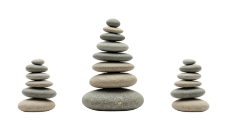 Stacked balancing stones arranged in three piles on a white background, symbolizing harmony and meditation, perfect for wellness and mindfulness themes
