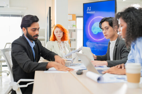 Diverse business professionals, both male and female, collaborate in a bright modern office, using an AI-powered virtual assistant to brainstorm innovative ideas, analyze big data insights