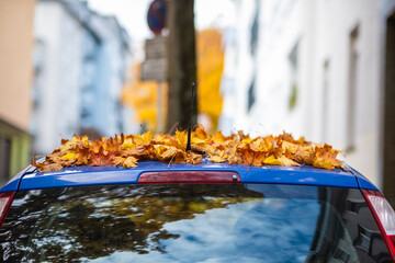 Ein Auto ist im Herbst mit einer dicken Schicht aus Herbstlaub bedeckt, Wuppertal, Deutschland