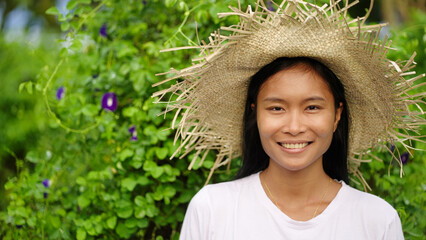 portrait of smiling young southeast asian woman farmer in straw farming hat looking at camera, asia