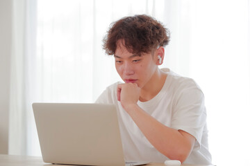 リビングでパソコン作業をする若い男性