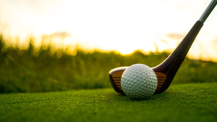 Golf clubs and balls on a green lawn in a beautiful golf course with morning sunshine.