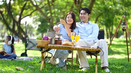 Happy asian family picnic in park, weekend lifestyle outdoors.