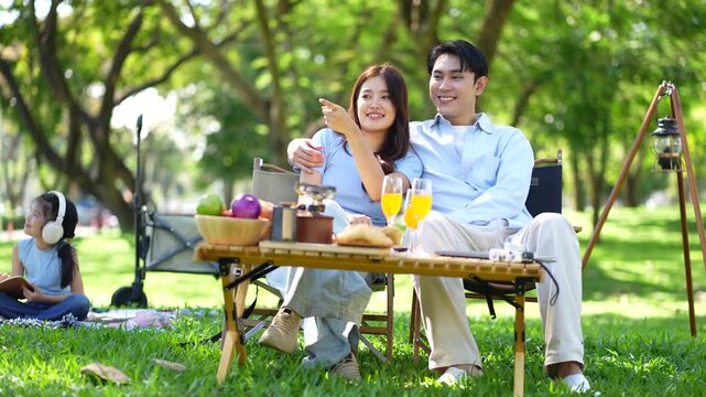 Happy asian family picnic in park, weekend lifestyle outdoors.