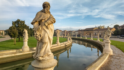 Fototapeta premium Historic statues lining the canal at Prato della Valle at sunrise, Padua, Italy