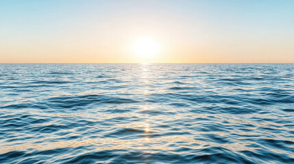 Obraz premium Calm ocean waves reflect sunlight under pastel sky, creating peaceful atmosphere