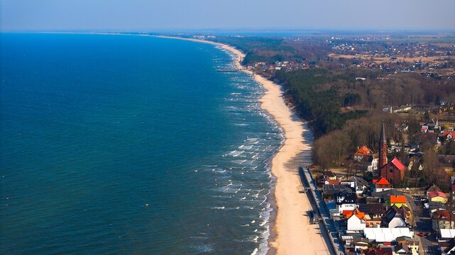 Baltic panorama with Sarbinowo&rsquo;s red-brick church and sandy beach below.