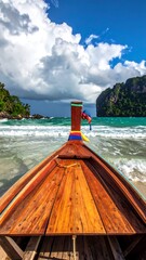 First-person view from a longtail boat, observing the ocean's expanse towards a mountainous island, waves lapping the shore under a cloudy sky