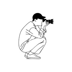 A photographer crouching while taking a picture, representing creativity, focus, and professional photography work.