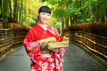 贈答品を手に持つ振袖姿の女性