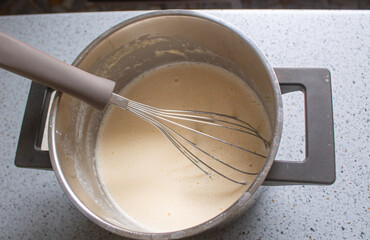 Whisk and Batter in Saucepan, Homemade Pancake or Crepe Mixture, Top View Cooking Process
