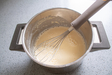 Whisk and Batter in Saucepan, Homemade Pancake or Crepe Mixture, Top View Cooking Process
