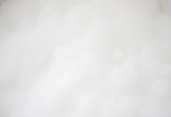 Fototapeta premium Close-up of fluffy, white bubble bath suds overflowing a tub, fluffy, bathroom