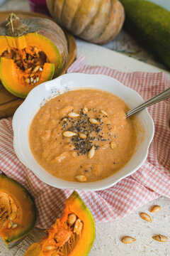 Pumpkin is a superfood. A pumpkin soup is a healthy food. It is healthy and nutritious food for autumn. A vitamin made from pumpkin and other vegetables on a rustic background.