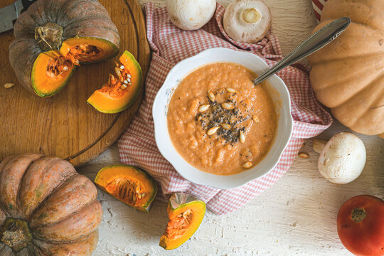 Pumpkin is a superfood. A pumpkin soup is a healthy food. It is healthy and nutritious food for autumn. A vitamin made from pumpkin and other vegetables on a rustic background.