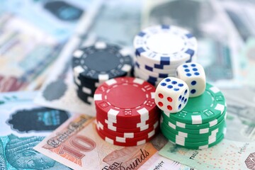 Egyptian pound currency money bills and casino chips with dices. The concept of gambling and poker casino games