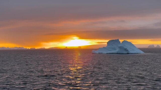 Stunning sunset over icy waters with floating icebergs in Antarctioca