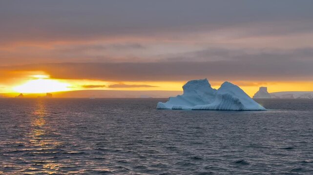 Stunning sunset over icy waters with floating icebergs in Antarctioca