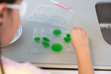 Children are learning and doing science experiments. Little girl playing science experiment for home schooling. Easy and fun science experiments for kids at home.