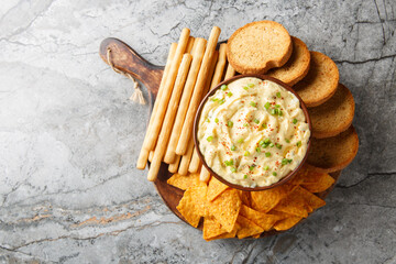 Deviled Egg Dip appetizer for a buffet or picnic with nachos, breadsticks and toast close-up on a...