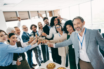 Diverse business team celebrating success together in a modern office setting