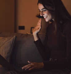 Obraz premium Happy caucasian young girl student watch webinar listen online course communicate by conference video call e learn language in app laugh study with teacher lesson look at laptop at night