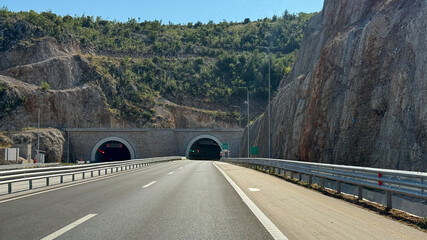 Sprawling asphalt artery snakes into dual canyon tunnels, evoking Cloverdales mysterious lore and unconventional Tunnel Day festivities