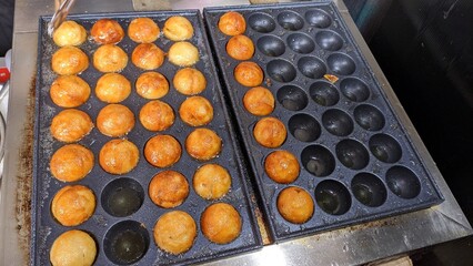 japanese octopus balls on the grill , cooking takoyaki