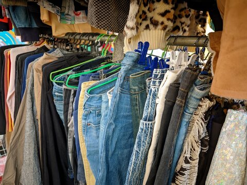 thrift store rack of used clothes and jeans