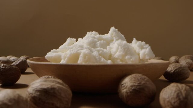 Wooden plate filled with shea butter and nuts, styled for cosmetic skincare branding video concept.