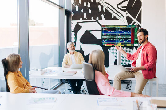 Business team analyzing stock market data during meeting