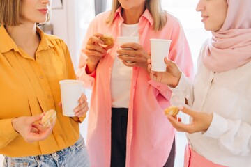 Diverse women friends enjoying coffee break and cookies