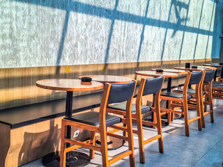 Arrangement of wooden tables and chairs in a cafe for customers who like the outdoors 