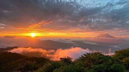 A breathtaking sunrise illuminates a mountainous landscape, casting golden hues over rolling hills and lush greenery.