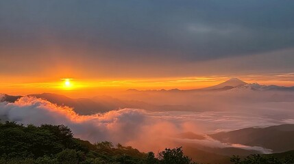 A breathtaking sunrise illuminates a mountain peak above a sea of clouds, casting golden hues across the landscape.