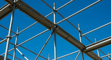 Fototapeta premium Close-up shot of interconnected metal scaffolding, set against a bright blue sky