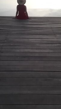 mulher sentada em deque no por do sol 