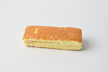 Soft rectangular sponge cake with filling on white background, minimal close-up bakery food photo, fluffy texture dessert ideal for pastry, snack, or breakfast concept.