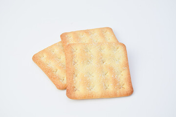 Close-up of three rectangular crackers on white background, crispy texture with sugar topping, minimal food composition for snack, bakery, or advertising concept.
