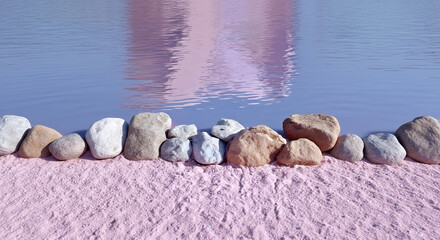 Colorful rocky shore by calm water reflecting pink tones