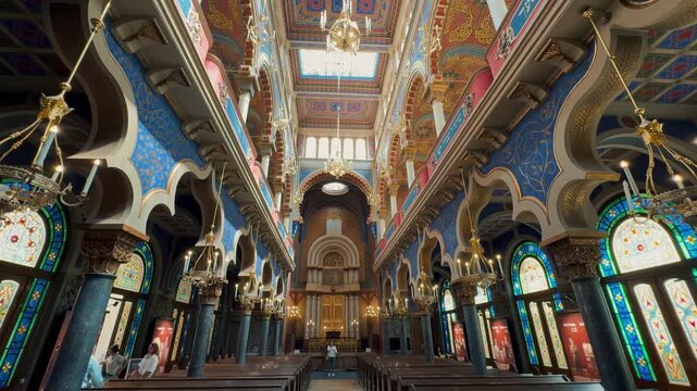 The opulent Neo-Moorish interior of the Spanish Synagogue in Prague, Czech Republic. Exquisite geometric patterns, vibrant colors, and elaborate gold ornamentation showcase 