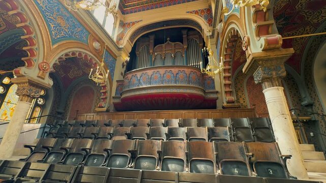 The opulent Neo-Moorish interior of the Spanish Synagogue in Prague, Czech Republic. Exquisite geometric patterns, vibrant colors, and elaborate gold ornamentation showcase 